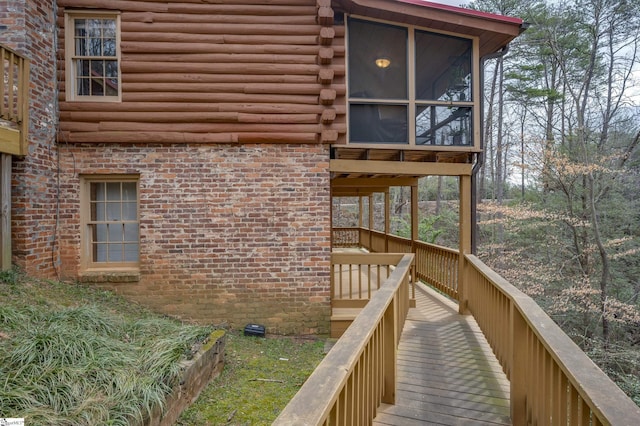 view of home's exterior with log exterior and a sunroom