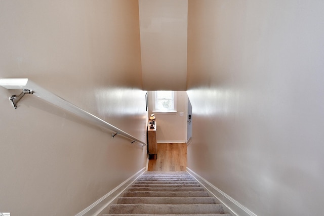 stairway featuring baseboards and wood finished floors