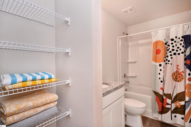 bathroom with visible vents, shower / tub combo with curtain, toilet, wood finished floors, and vanity