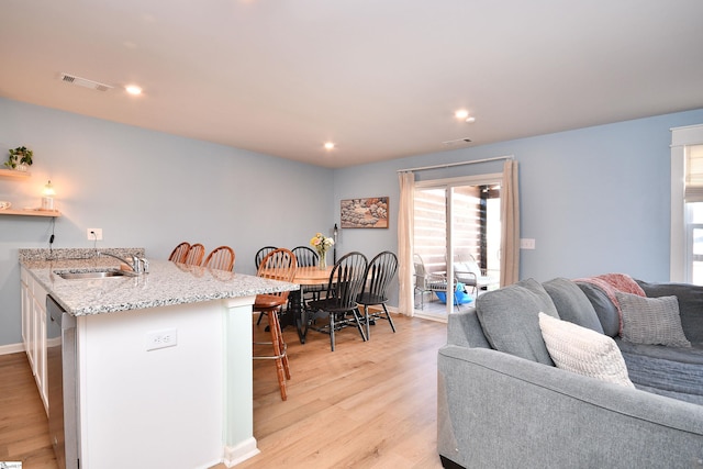 living area with light wood-style flooring, recessed lighting, visible vents, and baseboards