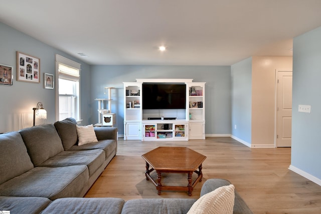 living area with visible vents, baseboards, and light wood finished floors