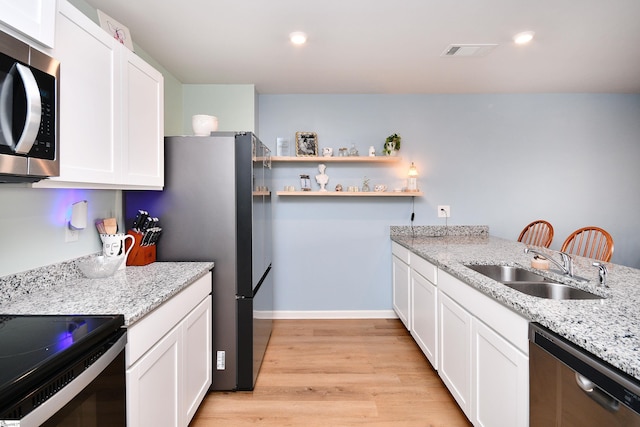 kitchen featuring visible vents, light wood-style floors, appliances with stainless steel finishes, and white cabinets