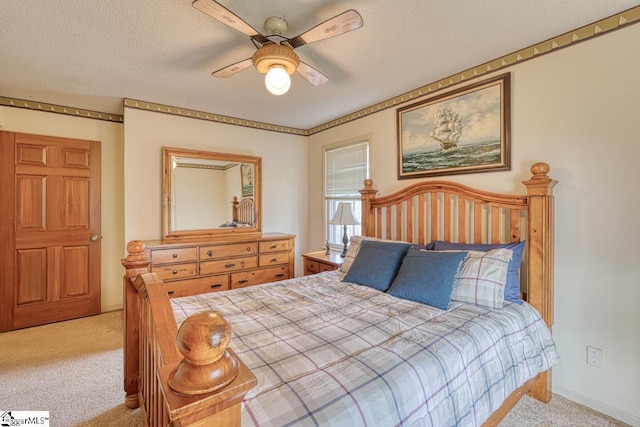 carpeted bedroom featuring a textured ceiling and ceiling fan