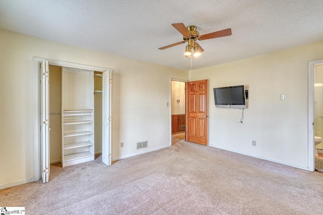 unfurnished bedroom featuring baseboards, carpet, visible vents, and a textured ceiling