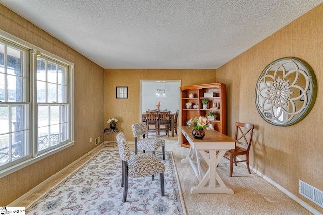 office area featuring visible vents, wallpapered walls, a textured ceiling, and baseboards