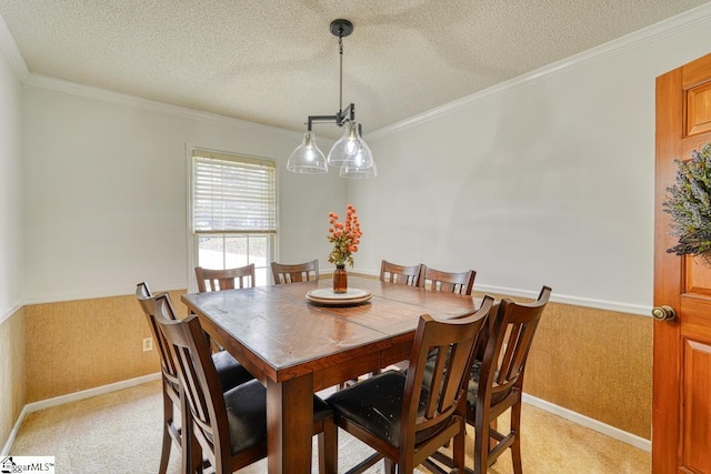 dining room with light carpet, a textured ceiling, and ornamental molding