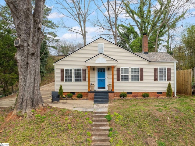 bungalow-style house with a front yard, fence, roof with shingles, a chimney, and crawl space