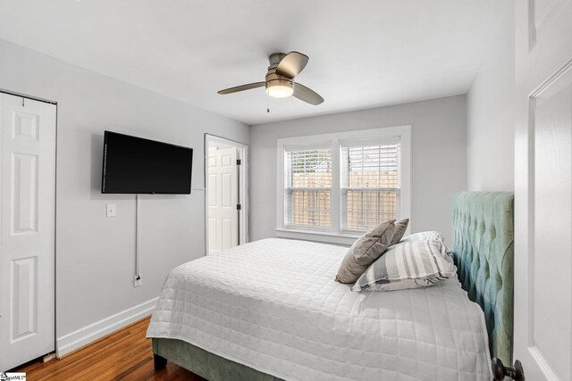 bedroom with ceiling fan, baseboards, and wood finished floors