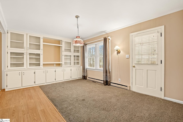 unfurnished dining area with light wood-type flooring, light carpet, and ornamental molding