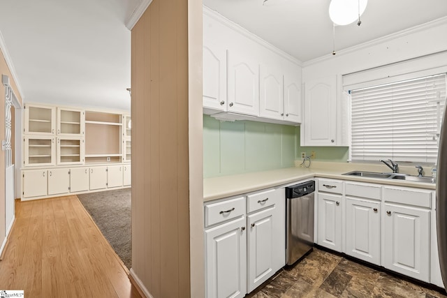 kitchen with ornamental molding, a sink, stainless steel dishwasher, white cabinetry, and light countertops