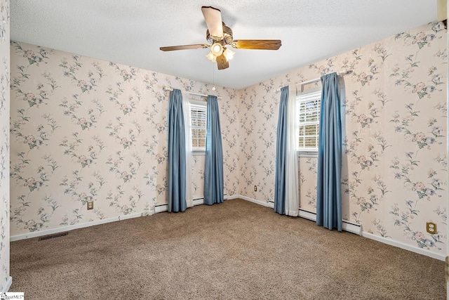 empty room with a textured ceiling, ceiling fan, carpet flooring, and wallpapered walls