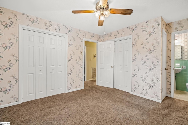 unfurnished bedroom featuring wallpapered walls, baseboards, and carpet floors