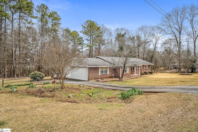 view of front facade featuring aphalt driveway, a garage, and a front yard