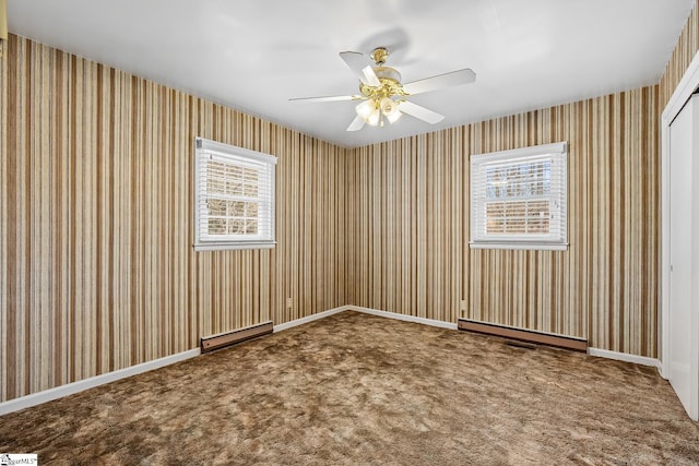 spare room with carpet floors, baseboard heating, ceiling fan, and plenty of natural light