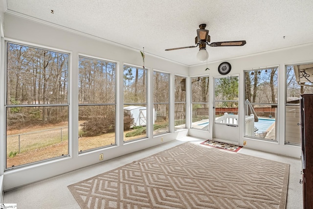 unfurnished sunroom featuring ceiling fan