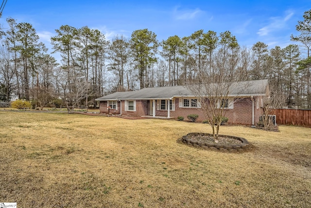 single story home featuring brick siding, a front yard, and fence