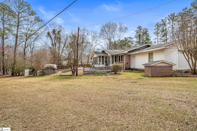 view of yard with fence and a sunroom