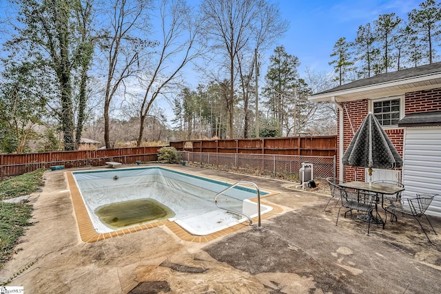 view of swimming pool featuring a fenced in pool, outdoor dining area, a fenced backyard, a diving board, and a patio area