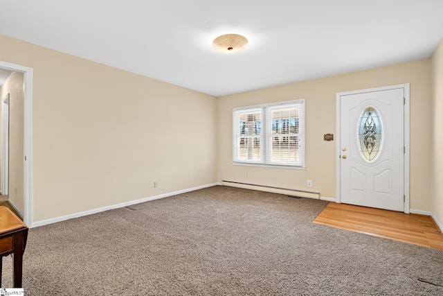 carpeted foyer featuring baseboard heating and baseboards