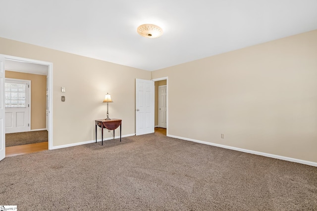 carpeted empty room featuring baseboards