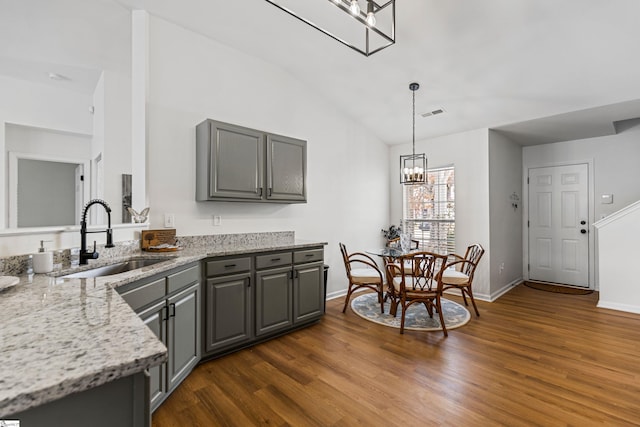 kitchen with a sink, dark wood finished floors, a chandelier, and gray cabinetry