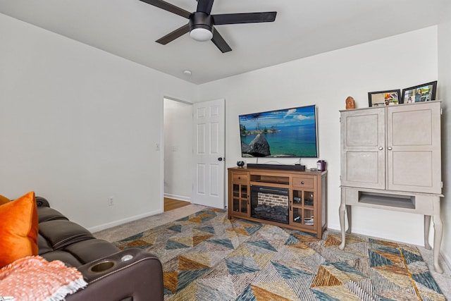 carpeted living area featuring baseboards and ceiling fan