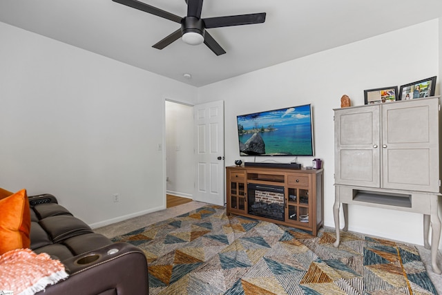 carpeted living room with baseboards and a ceiling fan