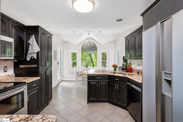 kitchen featuring light stone countertops, lofted ceiling, light tile patterned floors, a peninsula, and stainless steel appliances