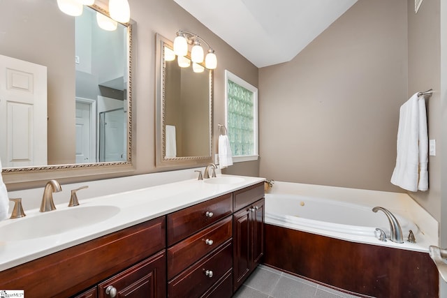 full bathroom featuring double vanity, tile patterned flooring, a garden tub, and a sink