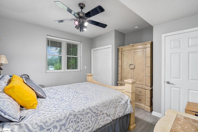 bedroom featuring ceiling fan, wood finished floors, a closet, and a textured ceiling