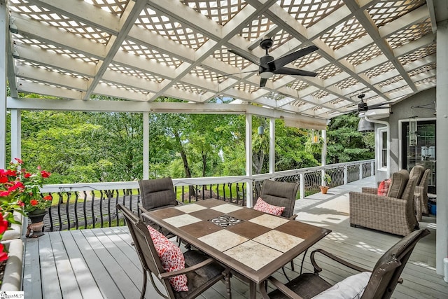 wooden deck with outdoor dining space, a pergola, and a ceiling fan