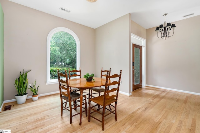 dining room featuring a notable chandelier, visible vents, and light wood-style floors