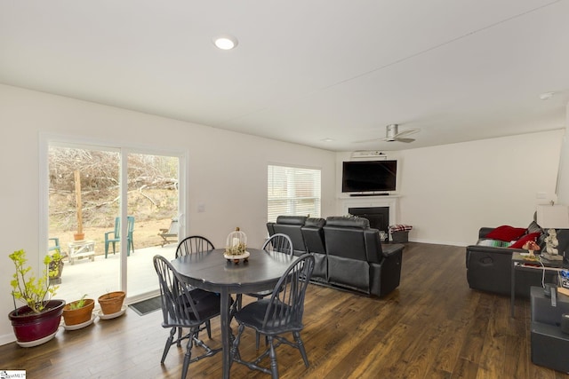 dining room with a ceiling fan, dark wood finished floors, recessed lighting, a fireplace, and baseboards