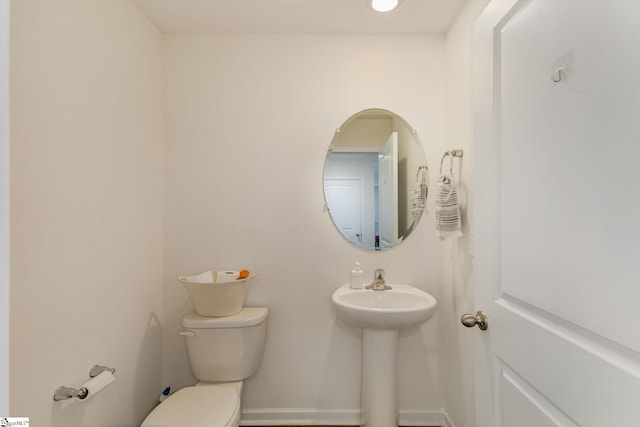 half bathroom with toilet and baseboards