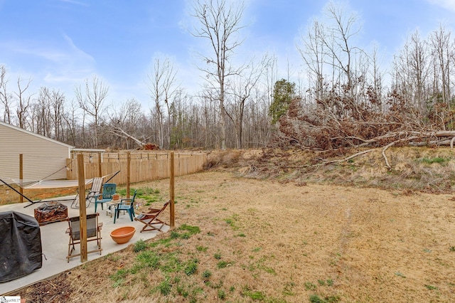 view of yard with a patio, fence, and an outdoor fire pit