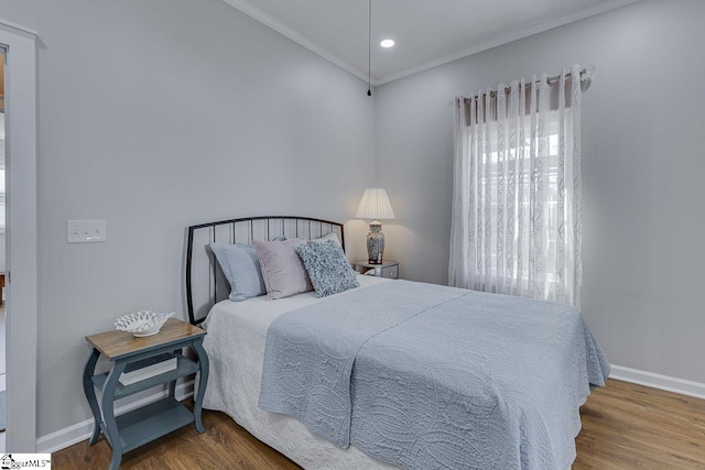 bedroom with recessed lighting, baseboards, wood finished floors, and crown molding