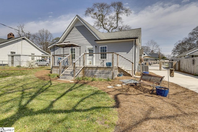 back of property featuring a shingled roof, fence, central air condition unit, concrete driveway, and a yard