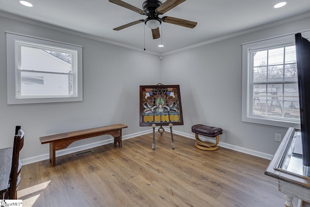 sitting room featuring wood finished floors, baseboards, and ornamental molding