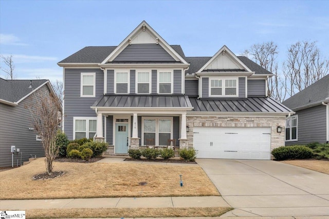 craftsman-style home with stone siding, driveway, metal roof, and a standing seam roof