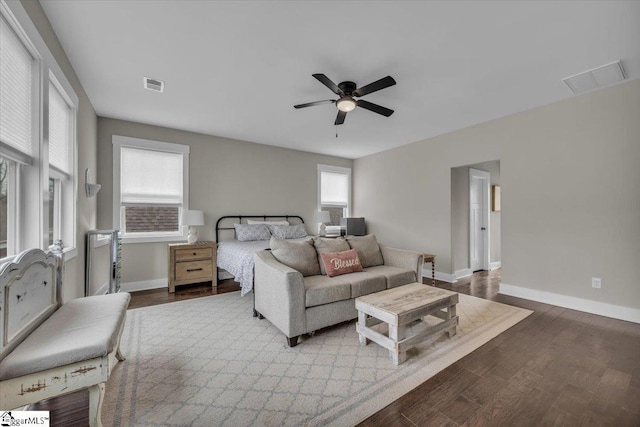 bedroom with visible vents, baseboards, and wood finished floors