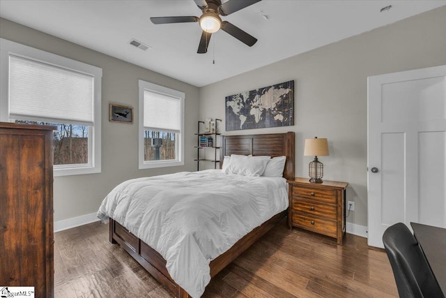 bedroom featuring visible vents, a ceiling fan, baseboards, and wood finished floors