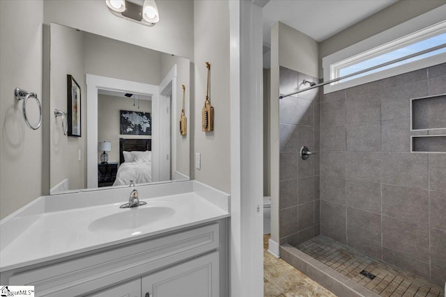 ensuite bathroom with tiled shower, ensuite bath, and vanity