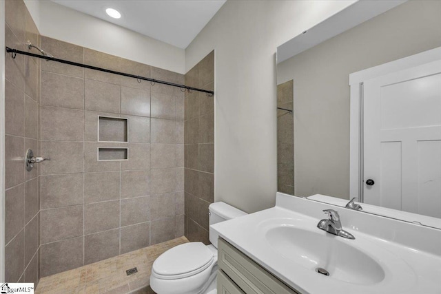 bathroom with a stall shower, toilet, and vanity