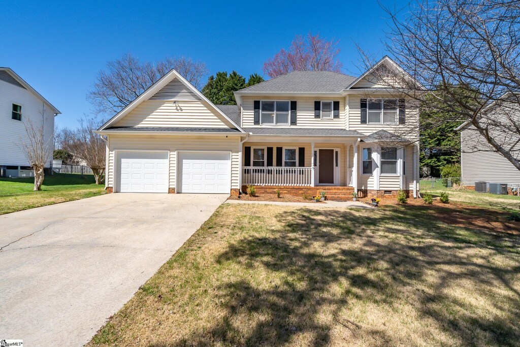 view of front facade with a garage, a porch, concrete driveway, and a front lawn