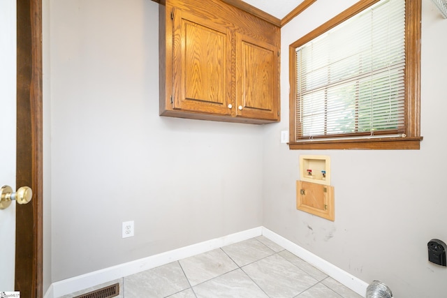 washroom featuring baseboards, hookup for an electric dryer, light tile patterned flooring, cabinet space, and washer hookup