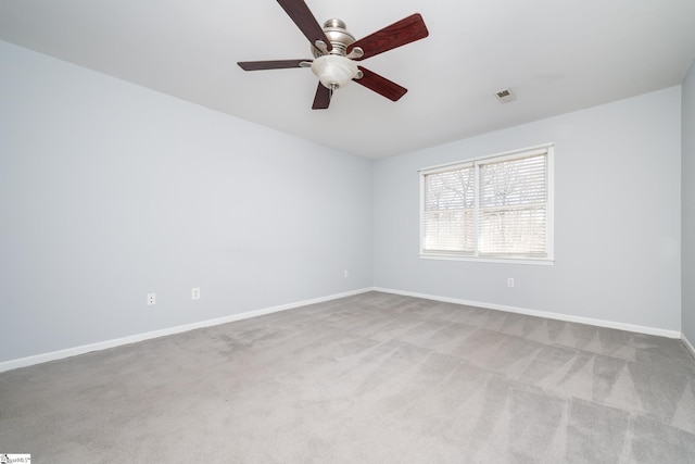 carpeted spare room featuring visible vents, baseboards, and a ceiling fan