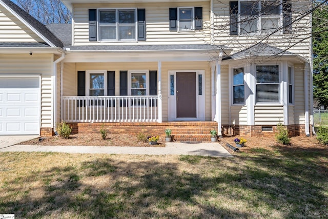 doorway to property with a porch, an attached garage, and a yard