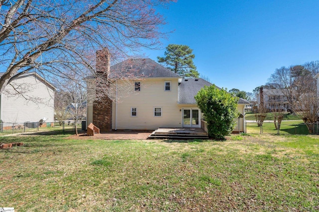 rear view of property with fence, a lawn, a chimney, a deck, and a gate