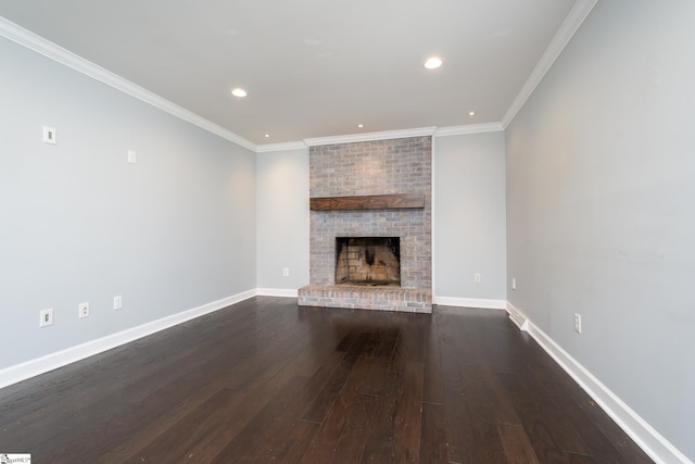 unfurnished living room featuring dark wood-style floors, a brick fireplace, crown molding, and baseboards