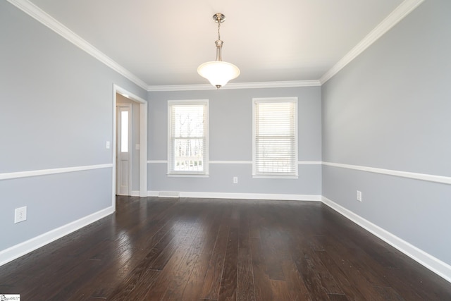 spare room featuring crown molding, baseboards, and wood finished floors